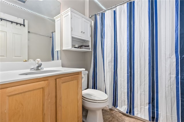 bathroom with curtained shower, vanity, and toilet