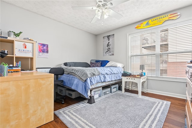 bedroom with multiple windows, a textured ceiling, ceiling fan, and dark wood-type flooring