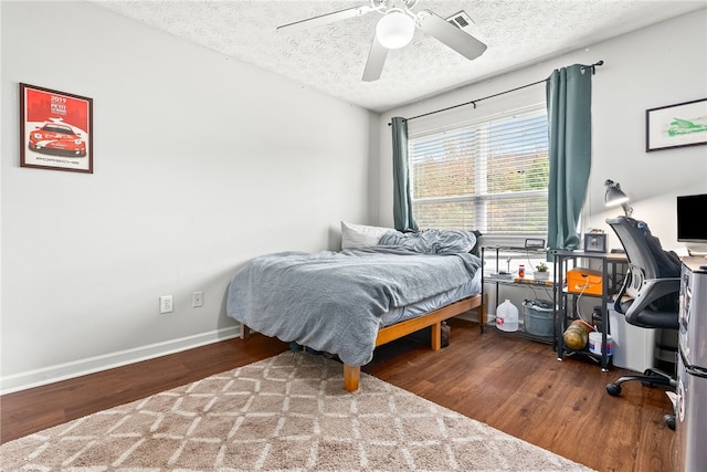 bedroom featuring hardwood / wood-style floors, ceiling fan, and a textured ceiling