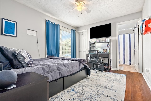 bedroom featuring a textured ceiling, ceiling fan, and dark wood-type flooring