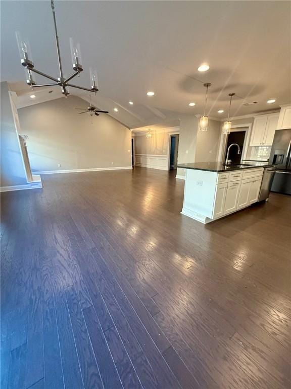 kitchen featuring stainless steel refrigerator with ice dispenser, sink, pendant lighting, white cabinetry, and lofted ceiling