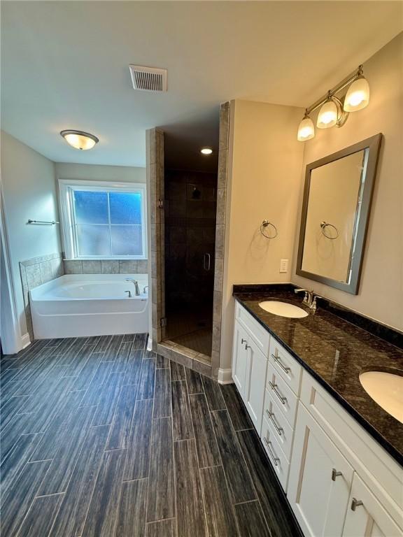 bathroom with vanity and separate shower and tub