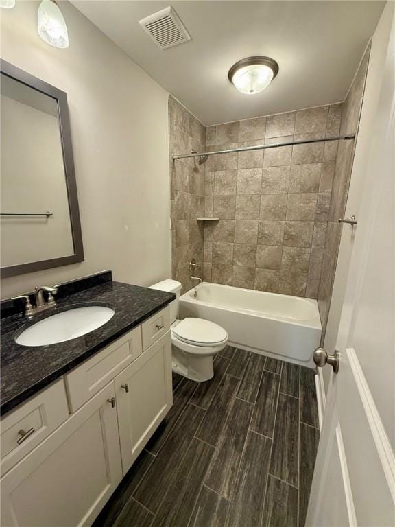 full bathroom featuring vanity, toilet, and tiled shower / bath