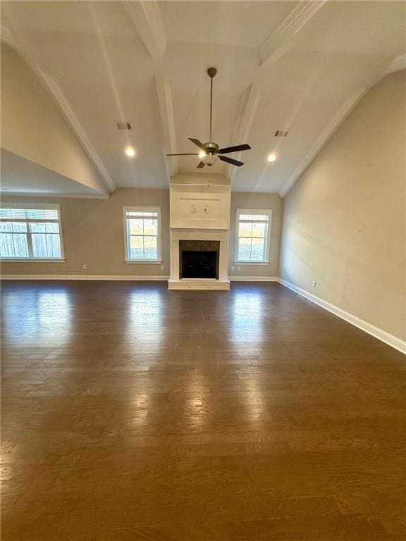 unfurnished living room with lofted ceiling with beams, ceiling fan, and a healthy amount of sunlight