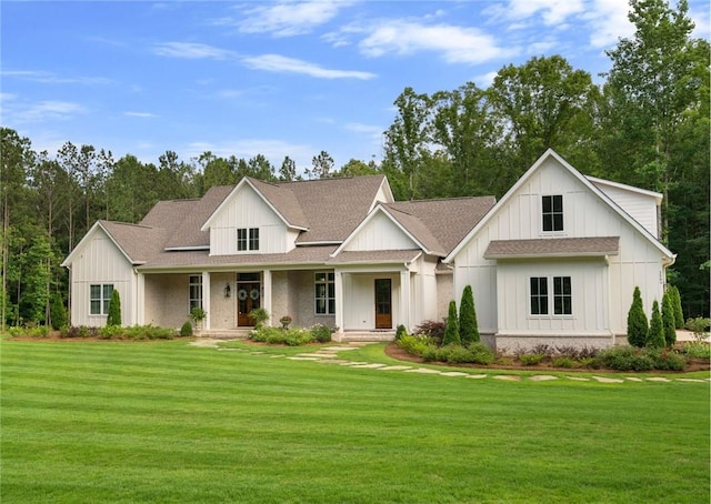 modern inspired farmhouse featuring a front lawn, board and batten siding, and roof with shingles