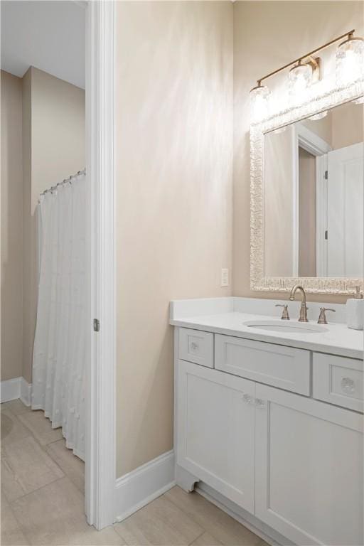 bathroom featuring tile patterned floors, baseboards, and vanity