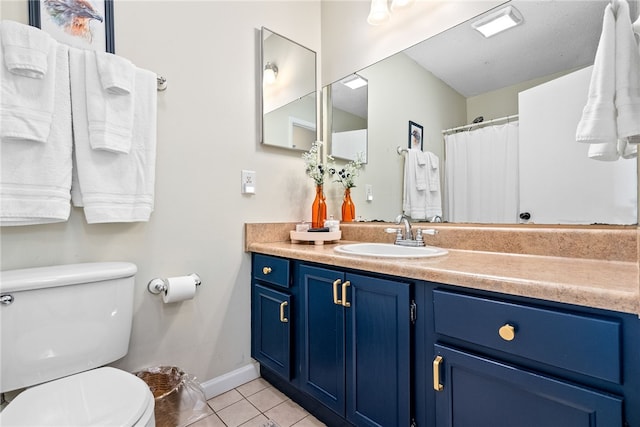 bathroom with tile patterned flooring, vanity, and toilet