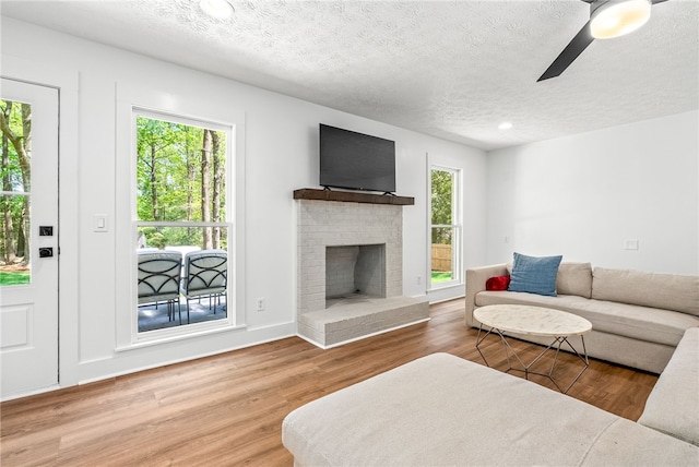 322 Cricket Ln, Auburn, AL 36832 - living room featuring a textured ceiling, wood finished floors, a fireplace, and ceiling fan