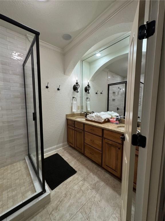 1336 Gatewood Dr, Auburn, AL 36830 - bathroom with a stall shower, crown molding, a textured wall, and double vanity