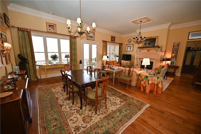 dining room with dark hardwood / wood-style floors, crown molding, a chandelier, and french doors