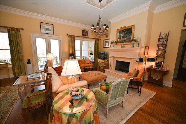 living room with dark hardwood / wood-style floors, an inviting chandelier, and ornamental molding