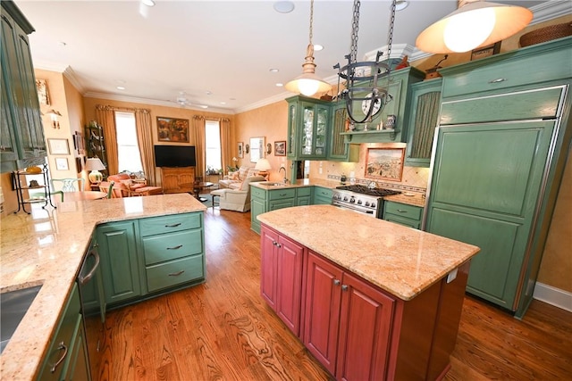 kitchen featuring ornamental molding, dark wood-type flooring, pendant lighting, and high end appliances