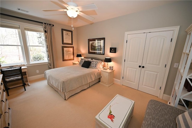 bedroom featuring ceiling fan, light colored carpet, and a closet