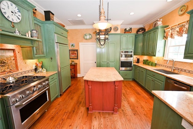 kitchen with sink, hanging light fixtures, premium appliances, light hardwood / wood-style floors, and a kitchen island