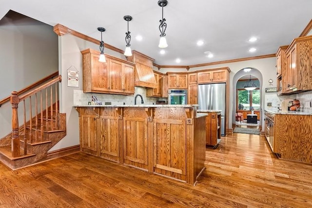 14699 Lee Road 188, Waverly, AL 36879 - kitchen with arched walkways, a peninsula, light wood-style floors, appliances with stainless steel finishes, and custom exhaust hood
