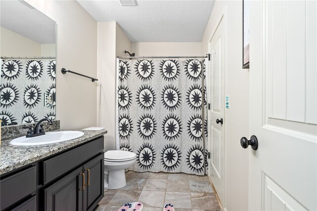 full bathroom featuring toilet, a shower with shower curtain, vanity, and a textured ceiling
