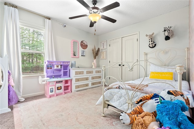 carpeted bedroom with baseboards, a ceiling fan, and a closet