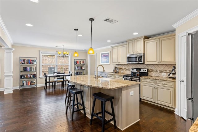 661 Deer Run Rd, Auburn, AL 36832 - kitchen featuring cream cabinetry, stainless steel appliances, ornate columns, a sink, and light stone countertops