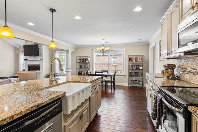 661 Deer Run Rd, Auburn, AL 36832 - kitchen with stainless steel appliances, a sink, decorative columns, a chandelier, and a tiled fireplace