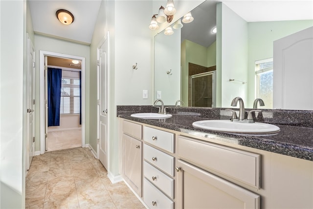 full bath with double vanity, vaulted ceiling, a stall shower, and a sink