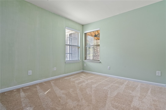 carpeted spare room featuring baseboards