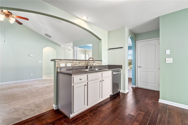 kitchen featuring visible vents, a sink, lofted ceiling, arched walkways, and stainless steel dishwasher