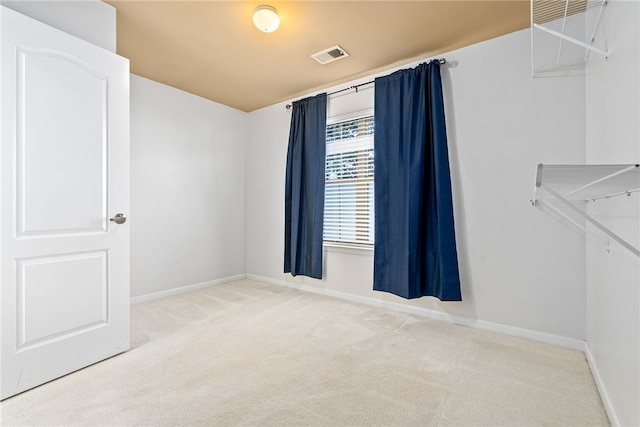 unfurnished room featuring visible vents, baseboards, and carpet