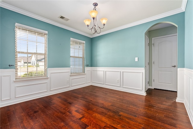 empty room featuring hardwood / wood-style floors, a notable chandelier, visible vents, and ornamental molding