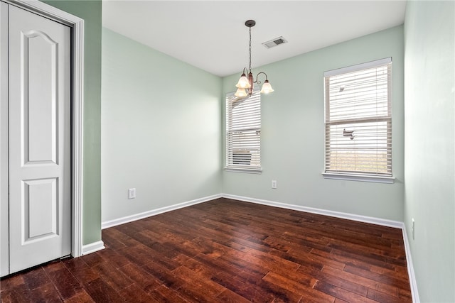 unfurnished room with visible vents, plenty of natural light, and dark wood-type flooring