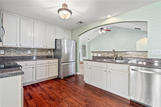 kitchen featuring a sink, dark wood-type flooring, white cabinets, appliances with stainless steel finishes, and dark countertops