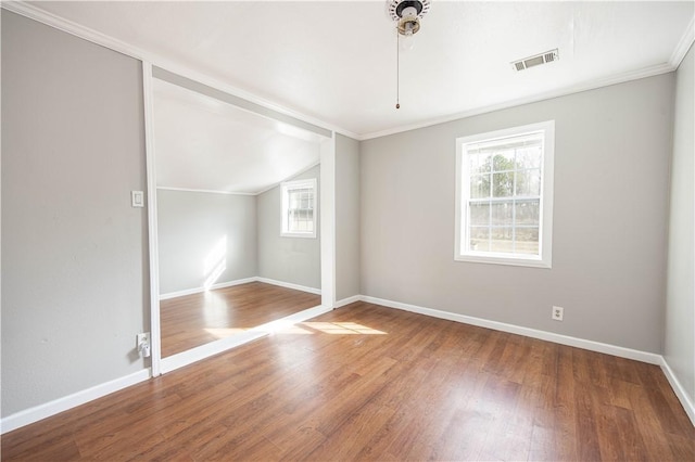 interior space with vaulted ceiling, baseboards, wood finished floors, and visible vents