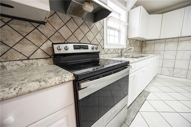 kitchen featuring wall chimney range hood, white cabinets, stainless steel electric range, and a sink