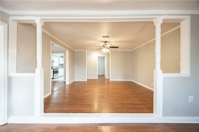 unfurnished room with crown molding, a ceiling fan, wood finished floors, and visible vents