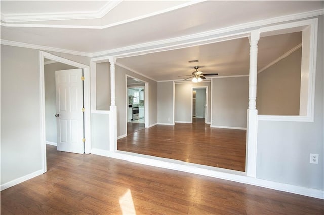 empty room featuring wood finished floors, crown molding, baseboards, a ceiling fan, and visible vents