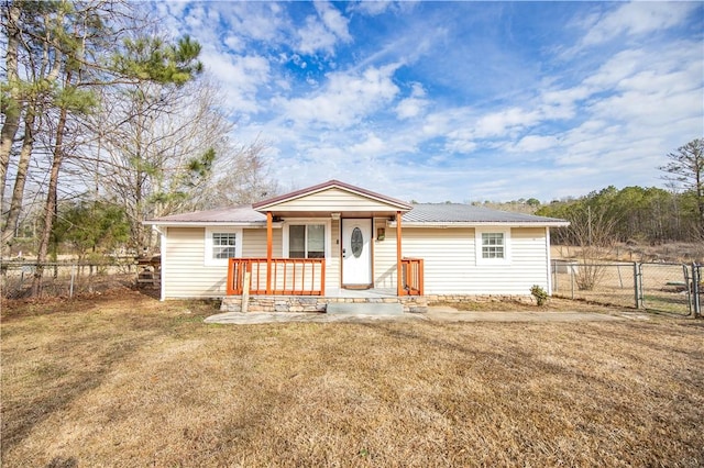 view of front of property with fence, a front yard, and metal roof