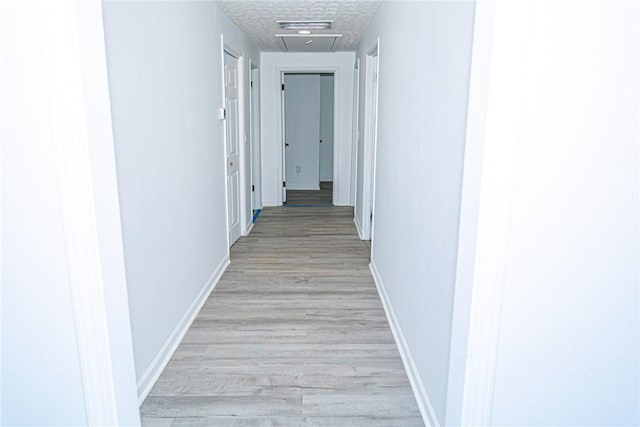 hallway with baseboards and light wood-style flooring