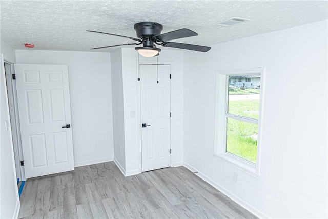 spare room with plenty of natural light, a textured ceiling, and wood finished floors