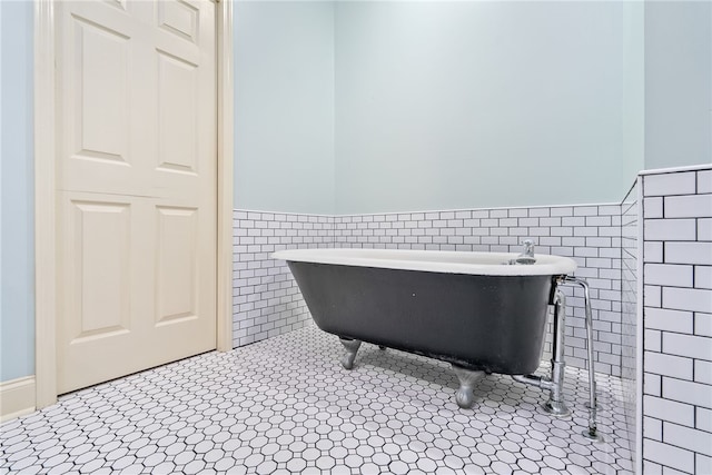1806 Bluestone Ct, Auburn, AL 36830 - bathroom featuring tile walls, wainscoting, a soaking tub, and tile patterned flooring