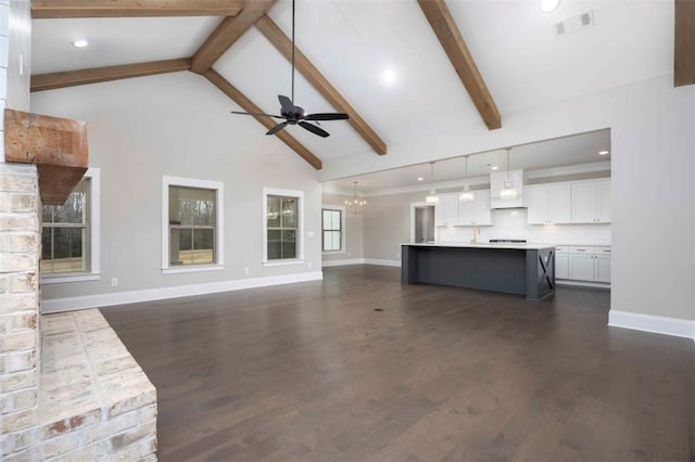 unfurnished living room featuring beamed ceiling, high vaulted ceiling, dark hardwood / wood-style floors, and ceiling fan with notable chandelier