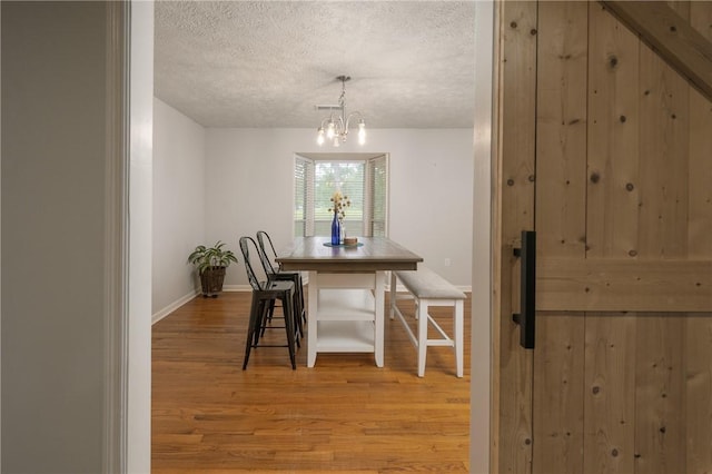 158 Lee Road 242, Phenix City, AL 36870 - dining room with a textured ceiling, light wood-style floors, a chandelier, and baseboards