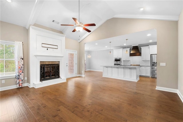 unfurnished living room with ceiling fan, hardwood / wood-style floors, and lofted ceiling