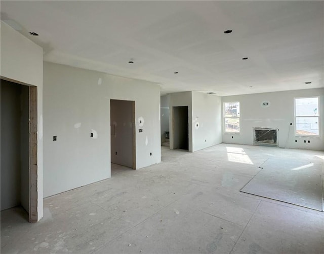 unfurnished living room with a fireplace and a wealth of natural light