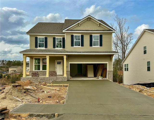 craftsman house with a garage, concrete driveway, brick siding, and covered porch