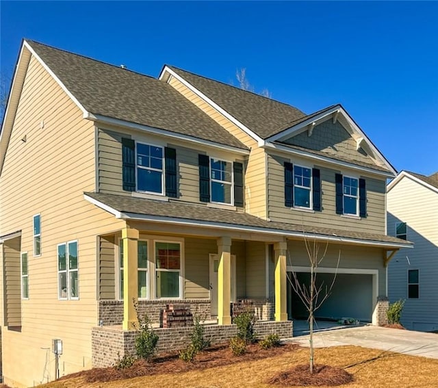 craftsman inspired home featuring a garage, roof with shingles, covered porch, and driveway