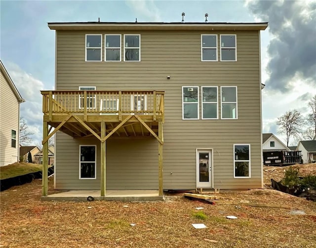 rear view of property featuring a patio area and a wooden deck