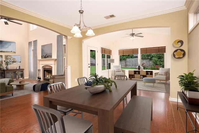 1931 Sequoia Dr, Auburn, AL 36879 - dining room featuring a ceiling fan, a fireplace, crown molding, wood finished floors, and arched walkways