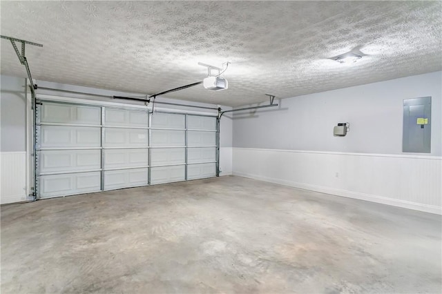 2331 Morgan Dr, Auburn, AL 36830 - garage featuring a garage door opener, electric panel, and a wainscoted wall