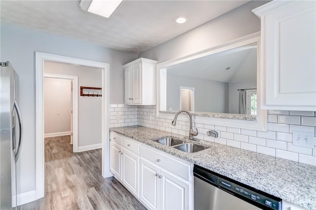 2331 Morgan Dr, Auburn, AL 36830 - kitchen featuring appliances with stainless steel finishes, white cabinets, decorative backsplash, light wood-style flooring, and light stone countertops
