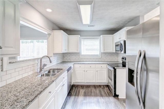 2331 Morgan Dr, Auburn, AL 36830 - kitchen featuring stainless steel appliances, white cabinetry, wood finished floors, tasteful backsplash, and light stone counters