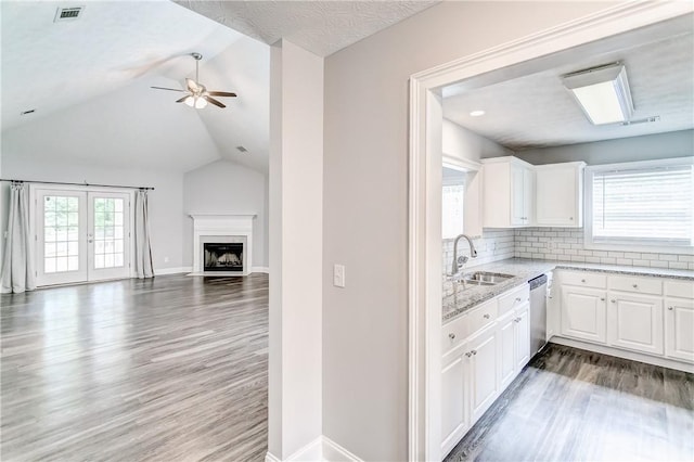 2331 Morgan Dr, Auburn, AL 36830 - kitchen featuring open floor plan, lofted ceiling, light stone counters, stainless steel dishwasher, and wood finished floors